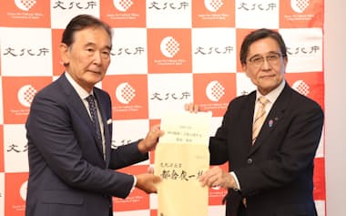 京都市の松井市長㊨は文化庁の都倉長官に要望書を手渡した(25日、京都市)