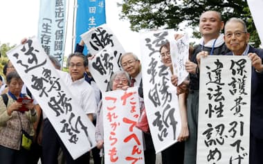 最高裁で勝訴し、喜ぶ原告や弁護士ら(6月、東京都千代田区)=共同