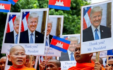 平和を求めるデモ行進でトランプ米大統領の写真を掲げるカンボジアの僧侶(8月10日、プノンペン)=ロイター