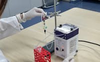 リンクセラピューティクスは患者の血液から病気の原因となる物質を取り除く治療法を目指す(小型装置の実験の様子)