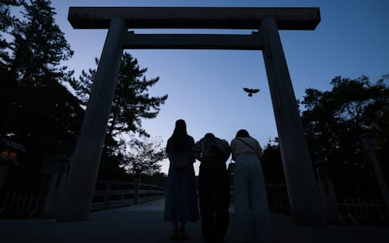 「朔日(ついたち)参り」で早朝から参拝客が訪れていた伊勢神宮内宮。大鳥居前で女性3人組が一礼して、宇治橋を渡っていった=加藤駿撮影 「朔日(ついたち)参り」で早朝から参拝客が訪れていた伊勢神宮内宮。大鳥居前で女性3人組が一礼して、宇治橋を渡っていった=加藤駿撮影
