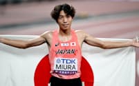 男子3000メートル障害決勝を終え、国旗を手にする三浦龍司
