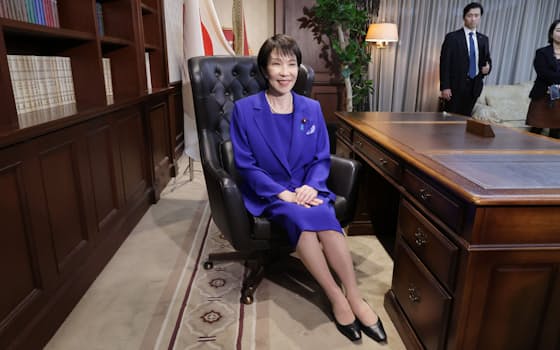 自民党総裁の椅子に座り、笑顔を見せる高市早苗新総裁(4日、党本部) 自民党総裁の椅子に座り、笑顔を見せる高市早苗新総裁(4日、党本部)