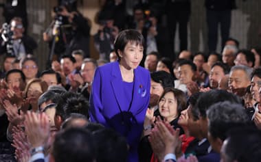自民党総裁選の決選投票で新総裁に選出され、起立する高市早苗氏(4日、党本部)