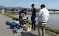 種もみを搭載中のドローン(5月、秋田県大仙市)=秋田県立大学提供
