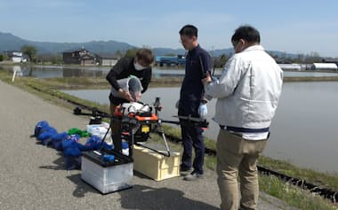 種もみを搭載中のドローン(5月、秋田県大仙市)=秋田県立大学提供