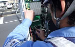 信号制御機を点検する作業員(東京都内)=警察庁提供 信号制御機を点検する作業員(東京都内)=警察庁提供