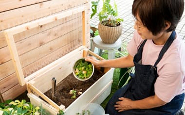 土に穴を掘って生ごみを入れる(東京都稲城市のコンポストフレンズ)=中岡 詩保子撮影