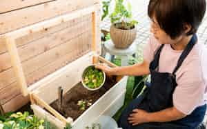 土に穴を掘って生ごみを入れる(東京都稲城市のコンポストフレンズ)=中岡 詩保子撮影 土に穴を掘って生ごみを入れる(東京都稲城市のコンポストフレンズ)=中岡 詩保子撮影