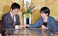 連立政権合意書に署名し、日本維新の会の吉村代表(左)にペンを手渡す自民党の高市総裁(20日、国会内)