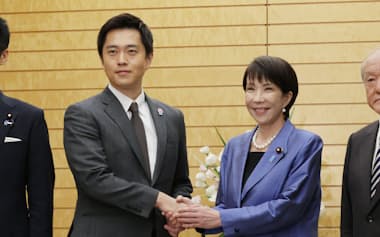 会談を前に握手する自民党の高市総裁と日本維新の会の吉村代表(21日、首相官邸)