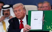ガザ和平の首脳級会合で文書に13日署名したトランプ米大統領(エジプト東部シャルムエルシェイク)=共同