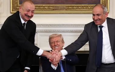 8月8日、米ホワイトハウスで固く握手するアゼルバイジャンのアリエフ大統領とトランプ米大統領、アルメニアのパシニャン首相(左から)=ロイター