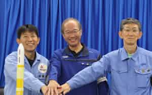 種子島宇宙センターで記者会見した三菱重工の志村康治氏㊧とJAXAの有田誠氏㊥(26日、鹿児島県南種子町) 種子島宇宙センターで記者会見した三菱重工の志村康治氏㊧とJAXAの有田誠氏㊥(26日、鹿児島県南種子町)