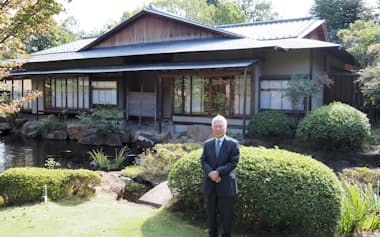 対局室「九重の間」がある離れの前に立つ常磐ホテルの笹本健次社長(甲府市)