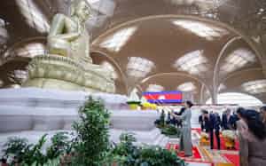 テチョ国際空港の開港を祝う式典に出席し、夫人とともにろうそくに火をともすカンボジアのフン・マネット首相(20日、プノンペン近郊)=ロイター テチョ国際空港の開港を祝う式典に出席し、夫人とともにろうそくに火をともすカンボジアのフン・マネット首相(20日、プノンペン近郊)=ロイター