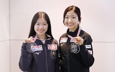 GP第3戦スケートカナダから帰国し、メダルを手に撮影に応じる千葉百音㊨と中井亜美(3日、羽田空港)=共同