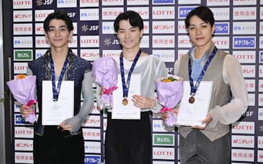 男子で優勝した杉山匠海。左は2位の中村俊介、右は3位の片伊勢武アミン(3日、木下カンセーアイスアリーナ)=共同