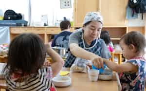 保育園で食事中の園児を見守る保育士 保育園で食事中の園児を見守る保育士