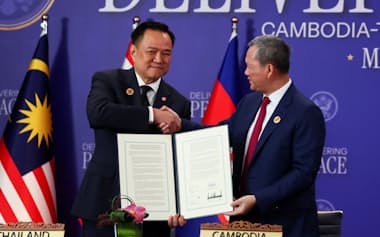 国境紛争の和平合意の調印式典に臨むタイのアヌティン首相㊧とカンボジアのフン・マネット首相(10月下旬、クアラルンプール)=ロイター