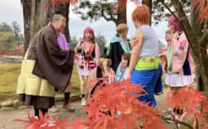 コスプレーヤーと話す南洞さん(左端、9日、岩手県平泉町) コスプレーヤーと話す南洞さん(左端、9日、岩手県平泉町)