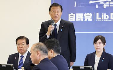 自民党の外国人政策本部の初会合であいさつする新藤本部長。右は小野田経済安保相、左は平口法相(11日、党本部)