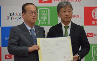 包括連携協定を結んだダイハツ工業の井上雅宏社長㊨と滋賀県竜王町の西田秀治町長(12日、滋賀県竜王町)
