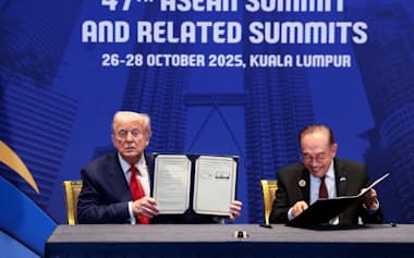 トランプ米大統領㊧とマレーシアのアンワル首相はASEAN関連首脳会議の期間中に2国間の貿易協定を結んだ(10月26日、クアラルンプール市内)=ロイター
