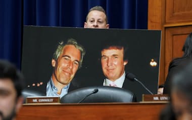 エプスタイン氏(パネルの左)とトランプ氏(同右)の写真を掲げる米民主党議員(2024年1月)=ロイター