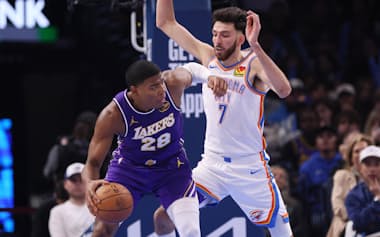 サンダー戦で相手と競り合いながらドリブルするレーカーズの八村㊧(12日、オクラホマシティー)=AP