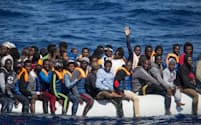 リビアから12カイリ沖の地中海で見つかった全長11メートルのゴムボートには、約150人がひしめき合うように乗っていた。イタリアを目指して海へ出た難民ボートのほとんどは、海上で救助される。無事イタリアまでたどり着いたボートは、これまで1隻もない。（PHOTOGRAPH BY HEREWARD HOLLAND）