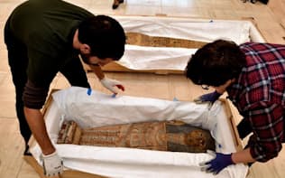 米国ワシントンD.C.のエジプト大使館で行われた返還式に展示するため、クレートから出される子どもの棺。米国に密輸されたもので、この後カイロに送り返される。（PHOTOGRAPH BY KENNETH GARRETT, NATIONAL GEOGRAPHIC SOCIETY）