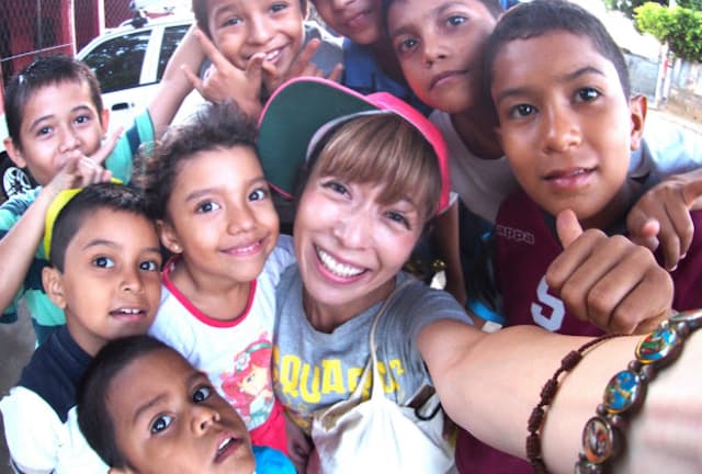 子どもたちと笑顔で「自撮り」するコジマサトコさん（ニカラグア　マナグアにて　コジマサトコさん提供）