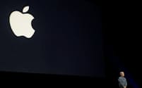アップルのロゴを背景に製品発表するティム・クックCEO（最高経営責任者）