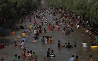 ラマダンの8日目を迎えた2017年6月4日、猛暑を避けようと運河で水浴びをするパキスタンの人々。ラホールでは、最高気温47℃を記録した。（PHOTOGRAPH BY RANA SAJID HUSSAIN, PACIFIC PRESS, LIGHTROCKET, GETTY IMAGES）