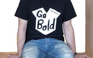 「Go Bold」とプリントしたTシャツを着た小泉さん