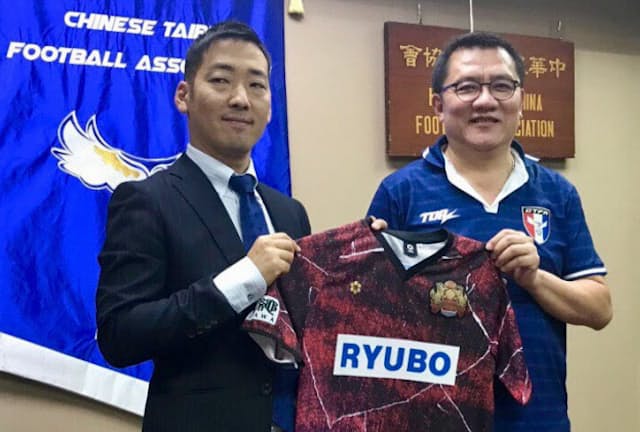 パートナーシップ協定を結びFC琉球のユニフォームを手にする倉林啓士郎社長（左）と台湾サッカー協会の林振義会長（2017年9月、台湾サッカー協会）＝FC琉球提供