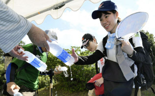熱中症予防のための飲み物を受け取り、現場へ向かうボランティア(21日午前、岡山県倉敷市)=共同 熱中症予防のための飲み物を受け取り、現場へ向かうボランティア(21日午前、岡山県倉敷市)=共同