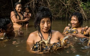ブラジル、アマゾンの先住民アワの女性たち。水浴びをしながらペットのカメを洗っている（PHOTOGRAPH BY CHARLIE HAMILTON JAMES, NATIONAL GEOGRAPHIC）