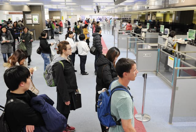 出国税は外国人だけでなく、日本人にも課税される（成田空港で入国審査を受ける外国人観光客ら）