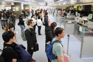 出国税は外国人だけでなく、日本人にも課税される(成田空港で入国審査を受ける外国人観光客ら)