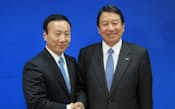 写真1　記者会見で握手する山田隆持社長（右）と加藤薫取締役常務執行役員（左）