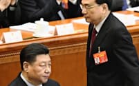 開幕した中国全人代で、政府活動報告のため席を立つ李克強首相。左は習近平国家主席（5日、北京の人民大会堂）=共同