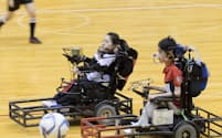 ボールを追って競り合う永岡真理（左）と東武範（2017年9月、日本電動車椅子サッカー選手権大会）=永岡一男提供