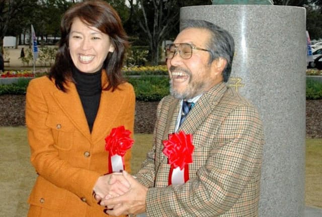 2004年12月、有森さんの銅像が制作された岡山県陸上競技場前で笑顔を見せる有森裕子さん（左）と小出義雄さん＝共同