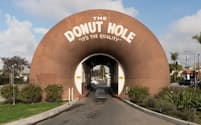 ラ・プエンテにあるドーナツ・ホールは店の両端に巨大なドーナツを配した建物で、ドライブスルーの車は2つのドーナツの下を通り抜けて注文する（PHOTOGRAPH BY THEO STROOMER）