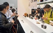 デジタルカメラの展示会「CP＋2013」のオリンパスのブースで小型デジカメを見る来場者（1月31日、横浜市）