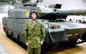 自衛隊ブースに展示された「10式」戦車と、同戦車を実際に操縦する浦松丈司自衛官