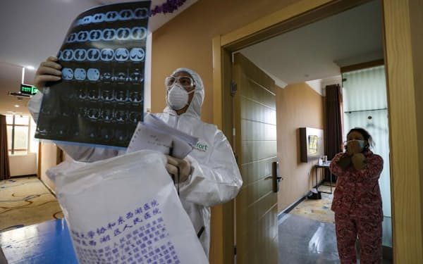 2020年2月3日、封鎖されている武漢の病院で、回診中に肺のCTスキャン画像を見る医師（PHOTOGRAPH BY STR/AFP VIA GETTY IMAGES）