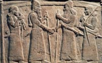 紀元前9世紀、バビロニア人と握手をするアッシリア王シャルマネセル3世をかたどったレリーフ。握手は古代の美術品にたびたび登場するモチーフだ（PHOTOGRAPH BY DEAGOSTINI, GETTY）